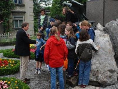 Norbert Schnetzer und die Kinder beim Denkmal.