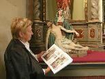 Bild: Pfarrkirchenrätin Hannelore Wehinger mit dem neuen Buch vor dem linken Altar in der Alten Kirche.