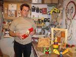 Johannes Gangel präsentiert in seiner Werkstatt im Keller einige bunte Werkstücke, darunter auch Spielzeug zum lernen.