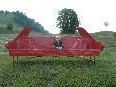 Ausrangierter Kleinwagen wurde zu einem roten Kunstsofa umgestaltet. Ausrangierter Kleinwagen wurde zu einem roten Kunstsofa umgestaltet.