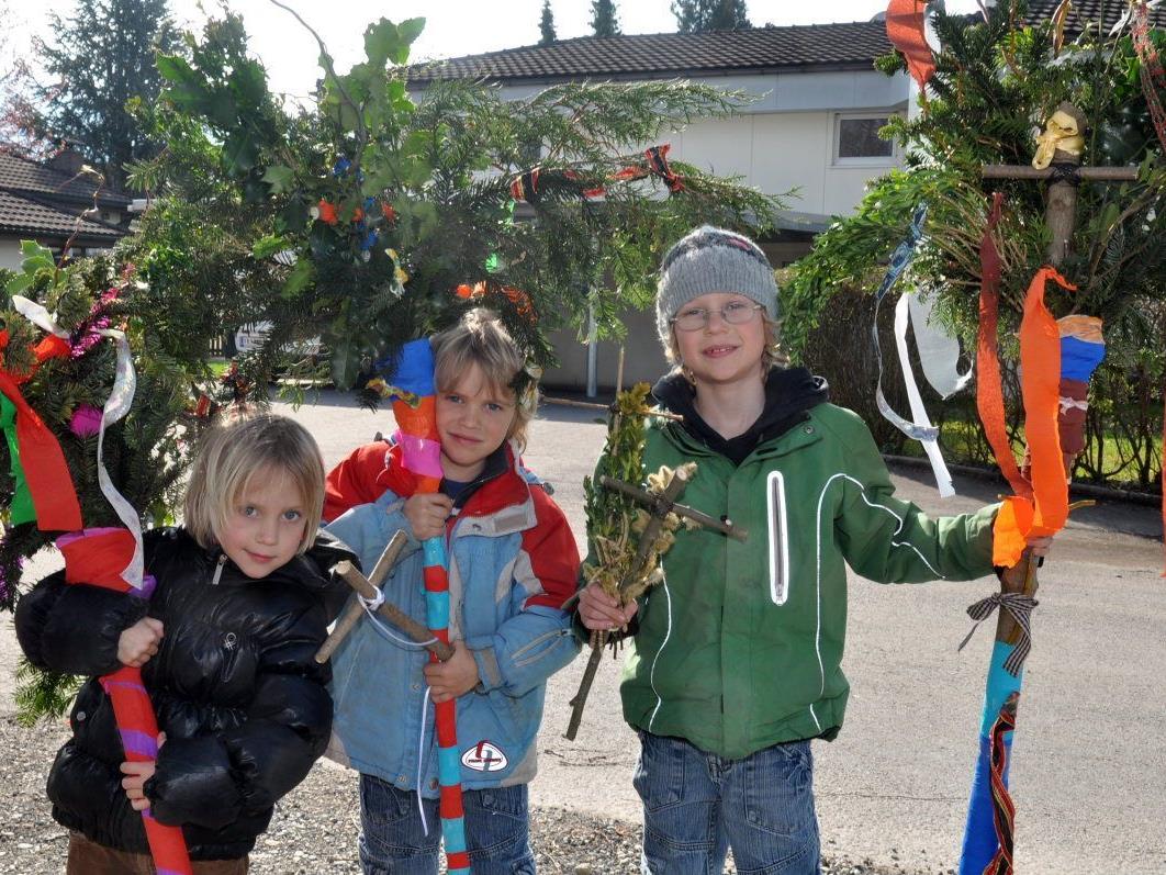 Laura, Noah und Elias freuen sich über ihre schönen Palmen, die am Sonntag vor dem Einzug in die Kirche gesegnet wurden.