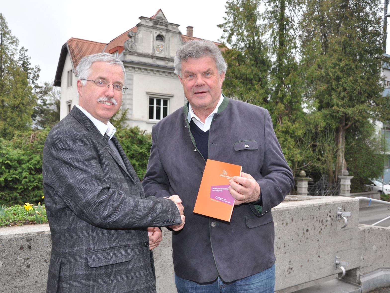 Der Obmann des Geschichtsvereins Region Bludenz, Otto Schwald, überreicht Bürgermeister Mandi Katzenmayer das druckfrische Doppelheft Nr. 101/102)