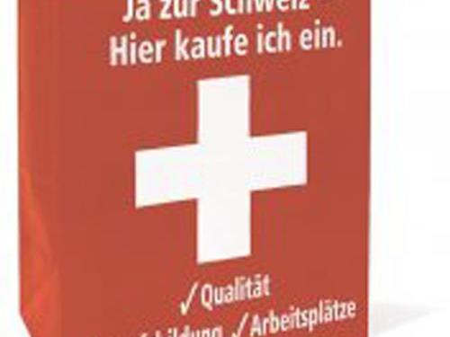 Mit dieser roten Papiertragtasche mit Schweizer Kreuz will der SVG die Schweizerinnen und Schweizer zum Nachdenken über das „System Schweiz“, anregen.