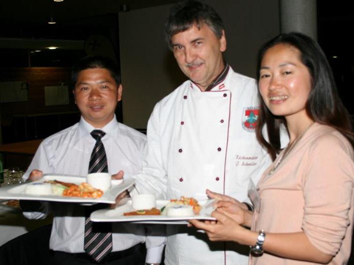Küchenmeister Schneider, Vizedir. Rongping, Lehrerin Ye Xiaoni servieren „Menü im Doppelpack“ – chinesisch und wälderisch.