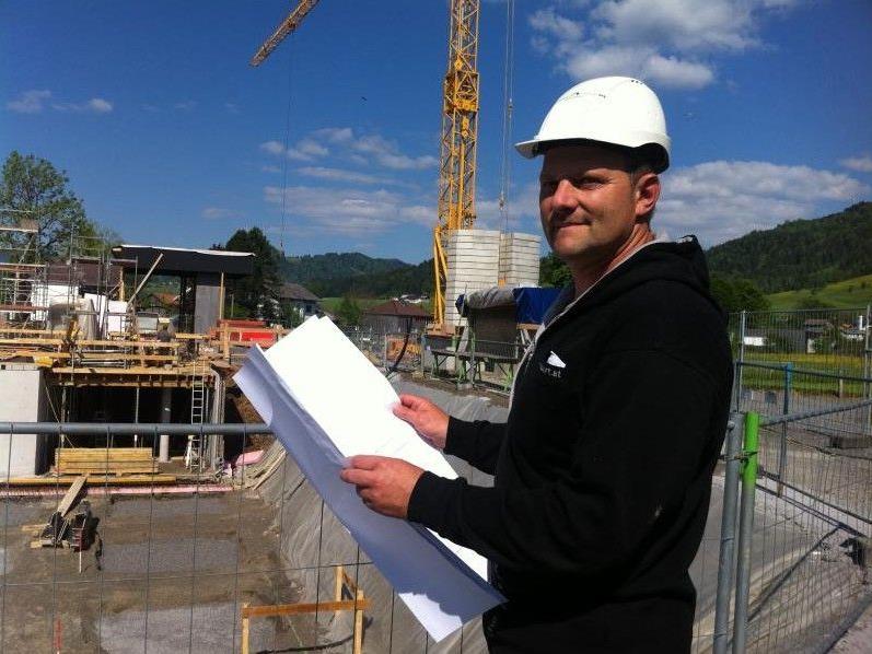 Baupolier Dietmar Kohler erläutert die Fortschritte der Bauarbeiten am Werkraumhaus in Andelsbuch.