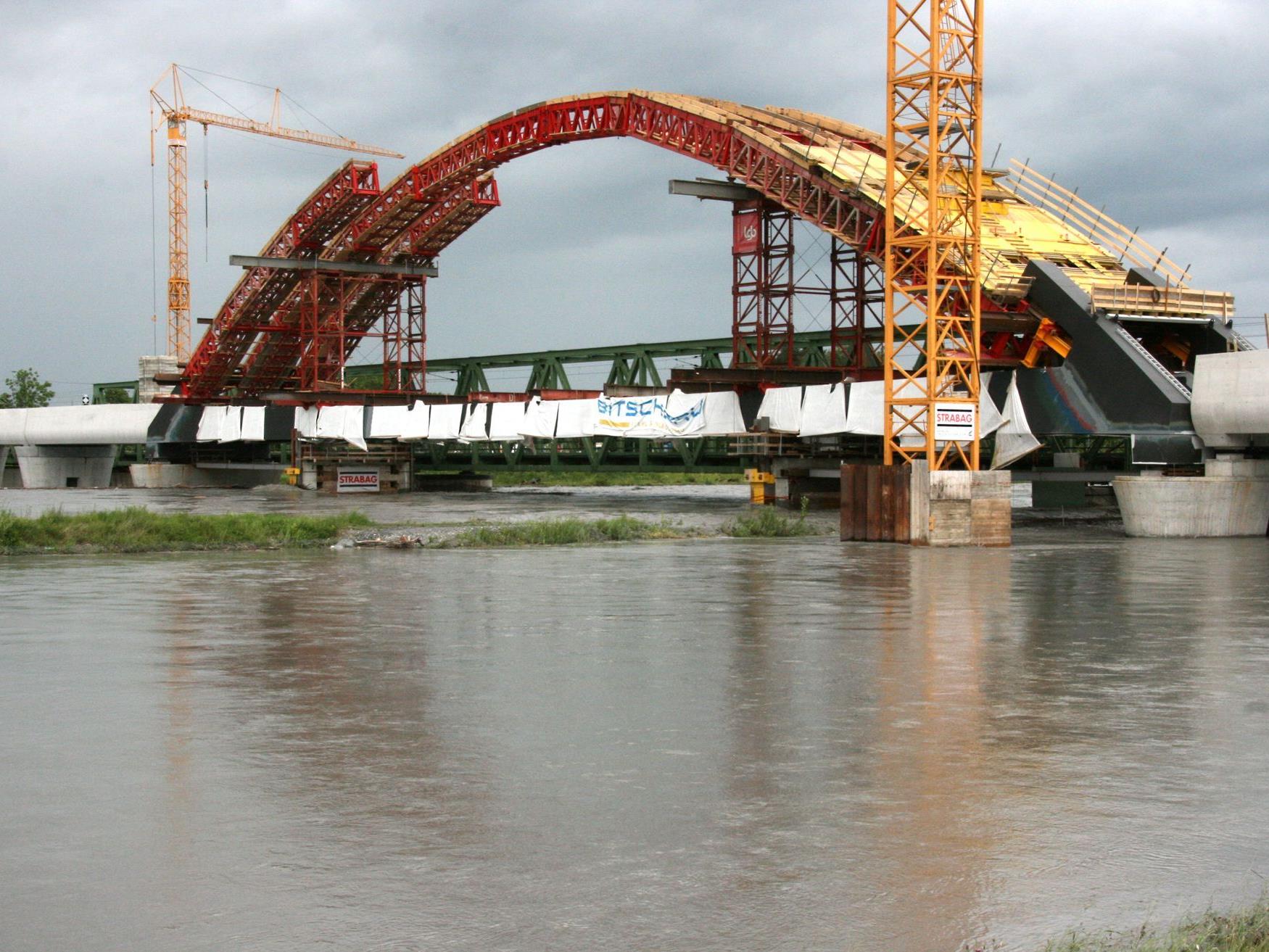 Die neue Rheinbrücke nimmt Form an, momentan stoppt der Hochwasser führende Rhein die Bauarbeiten.