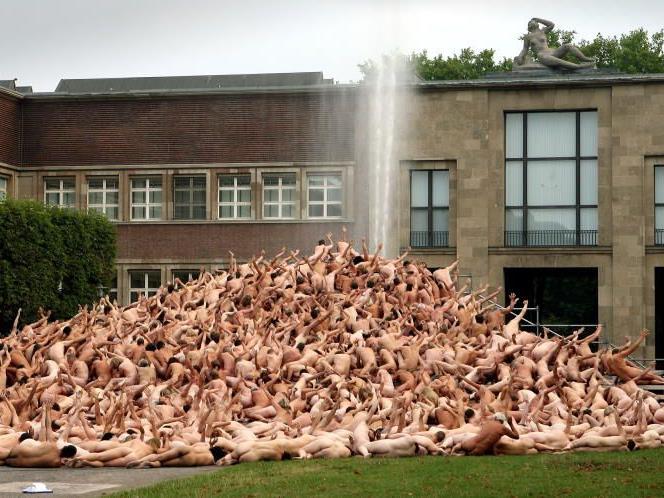 Mehrere hundert entkleidete Menschen stehen als Bestandteil einer Installation des Fotografen Spencer Tunick im Düsseldorfer Ehrenhof. In München kommt erstmals Farbe ins Spiel.
