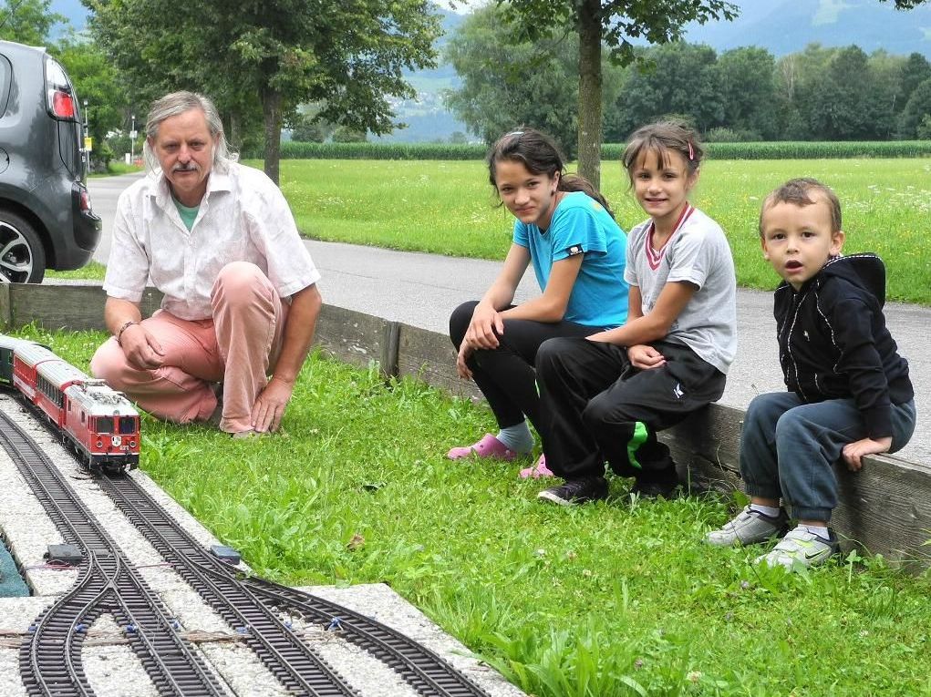 Josef Bischof mit seiner Gartenmodellbahnanlage und mehreren Kindern Josef Bischof mit seiner Gartenmodellbahnanlage und mehreren Kindern