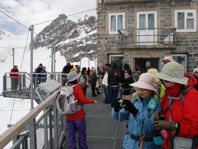 Asiatische Touristen auf der Aussichtsplattform Sphinx über dem Jungfraujoch.