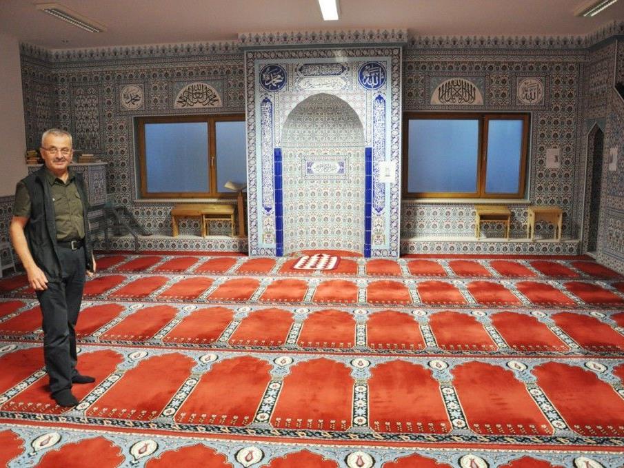 Bahri Yilmaz zeigt den schön gekachtelten Gebetsraum mit dem Gebetsteppich.
