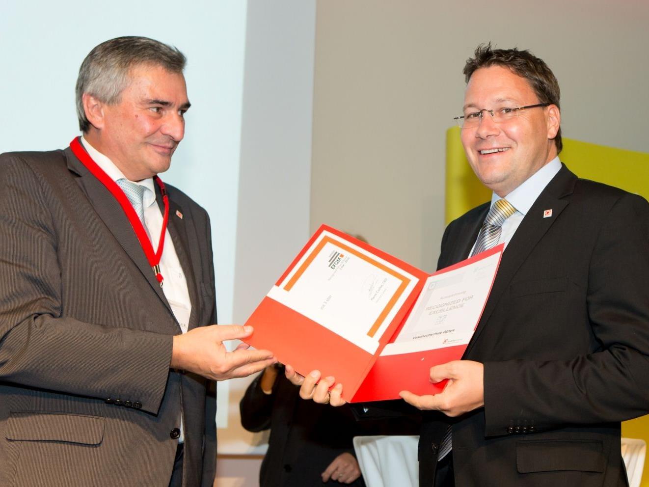 VHS Geschäftsführer Mag. Stefan Fischnaller nimmt von Vertretern der Quality Austria die Auszeichnung entgegen.