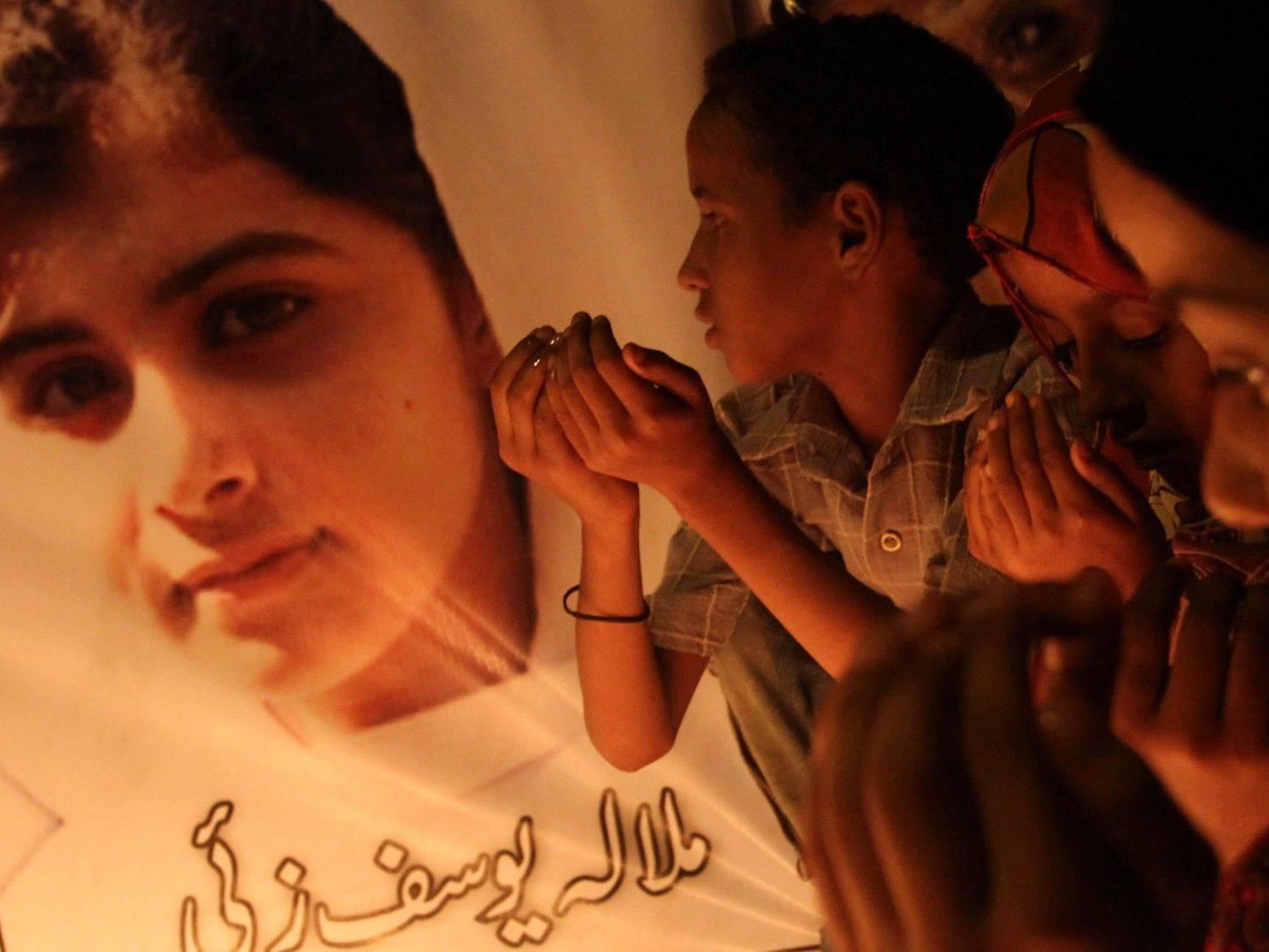 Pakistanische Kinder beten für die angeschossene Kinderaktivistin Malala Yousafzai.