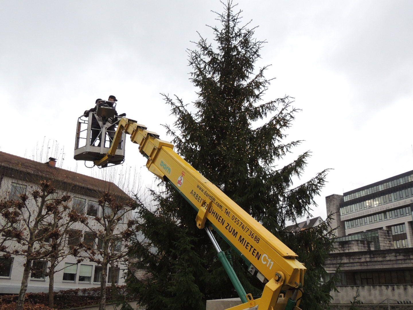 Landhaus Mitarbeiter sorgen für einen festlichen Christbaum vor dem Landhaus