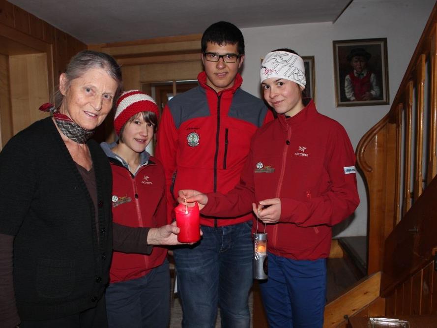 Anni bekam das Friedenslicht von den jungen Bergrettern Michaela, Stefan und Magdalena.