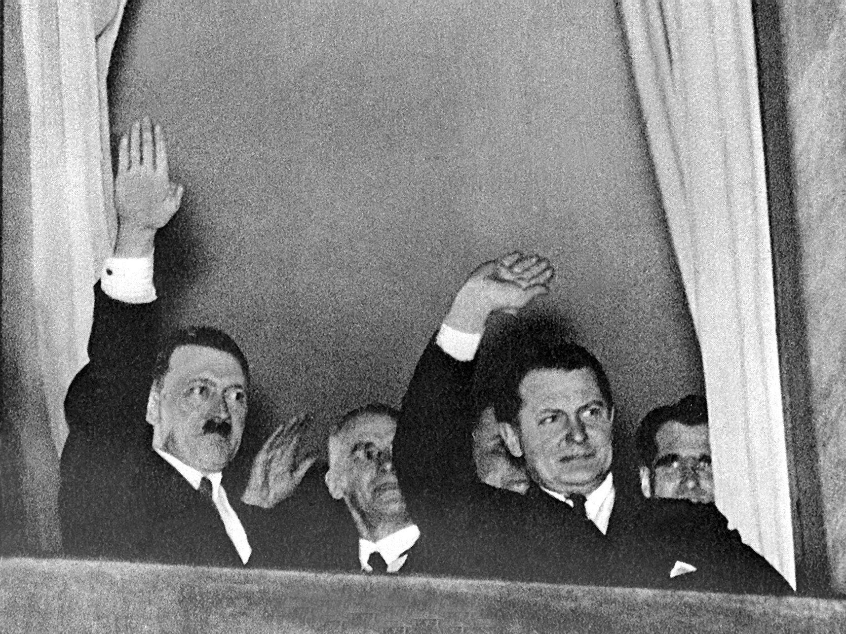 Der neu ernannte Reichskanzler Adolf Hitler (l) grüßt nach der Machtübernahme am 30. Januar 1933 aus einem Fenster in Berlin heraus den vorbeiziehenden Fackelzug.