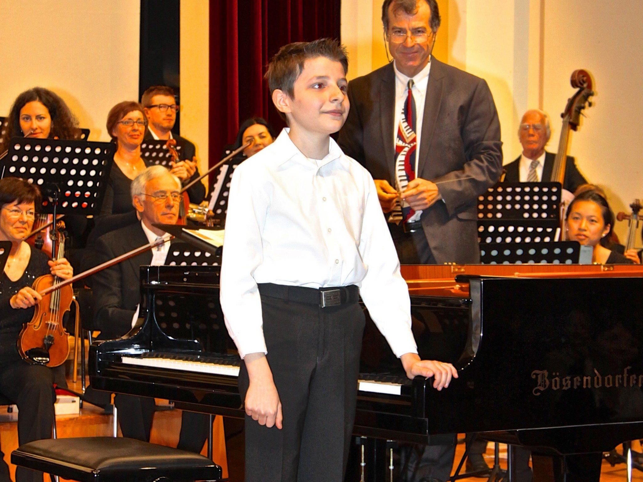Gabriel Meloni, der 12-jährige Meister am Bösendorfer (rechts Dirigent Murat Üstün)