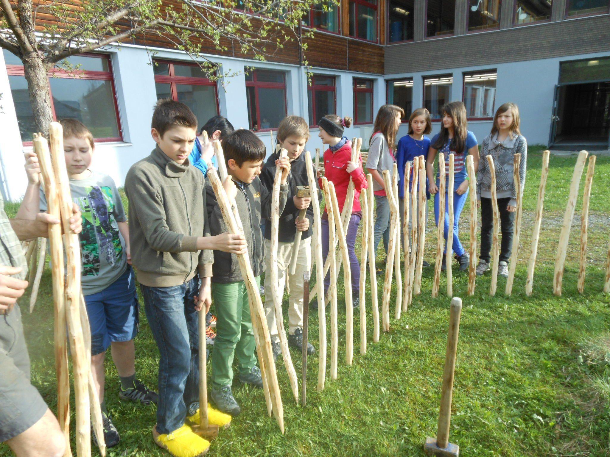 Die Schüler schlugen die Zaunpfähle, die sie selbst hergestellt hatten, rund um das Biotop ein.