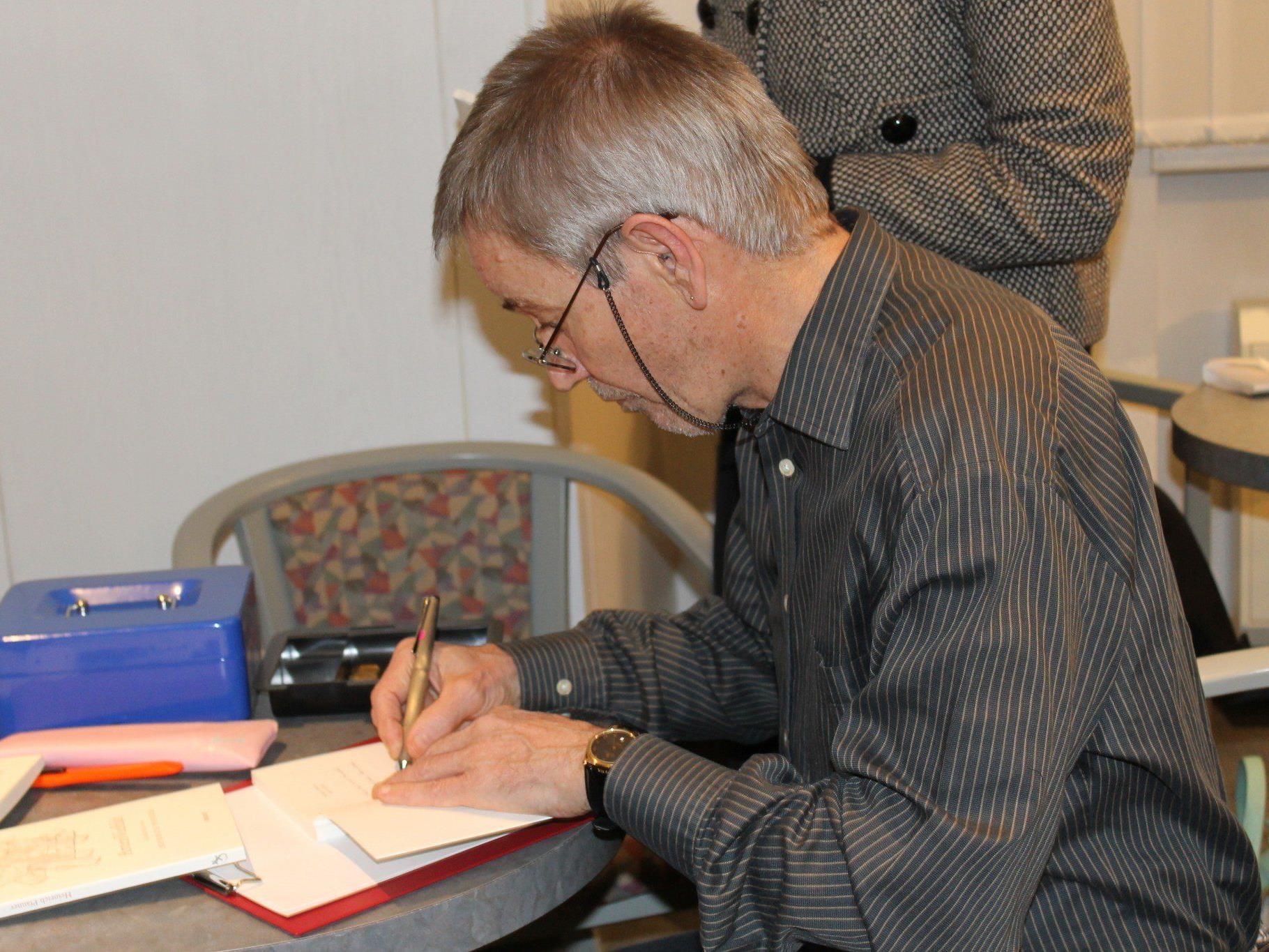 Der Autor beim Signieren seines Werkes