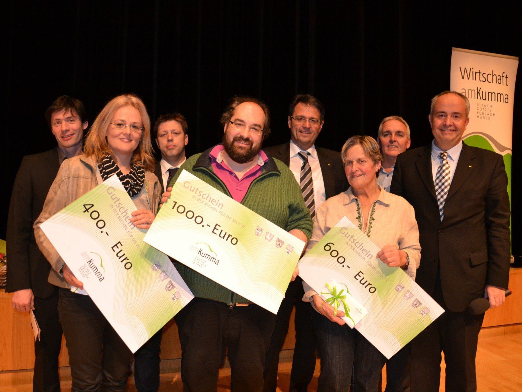 Die glücklichen Gewinner des Weihnachtsgewinnspieles 2013 auf der Bühne AMBACH mit dem WG amKumma Vorstand Die glücklichen Gewinner des Weihnachtsgewinnspieles 2013 auf der Bühne AMBACH mit dem WG amKumma Vorstand
