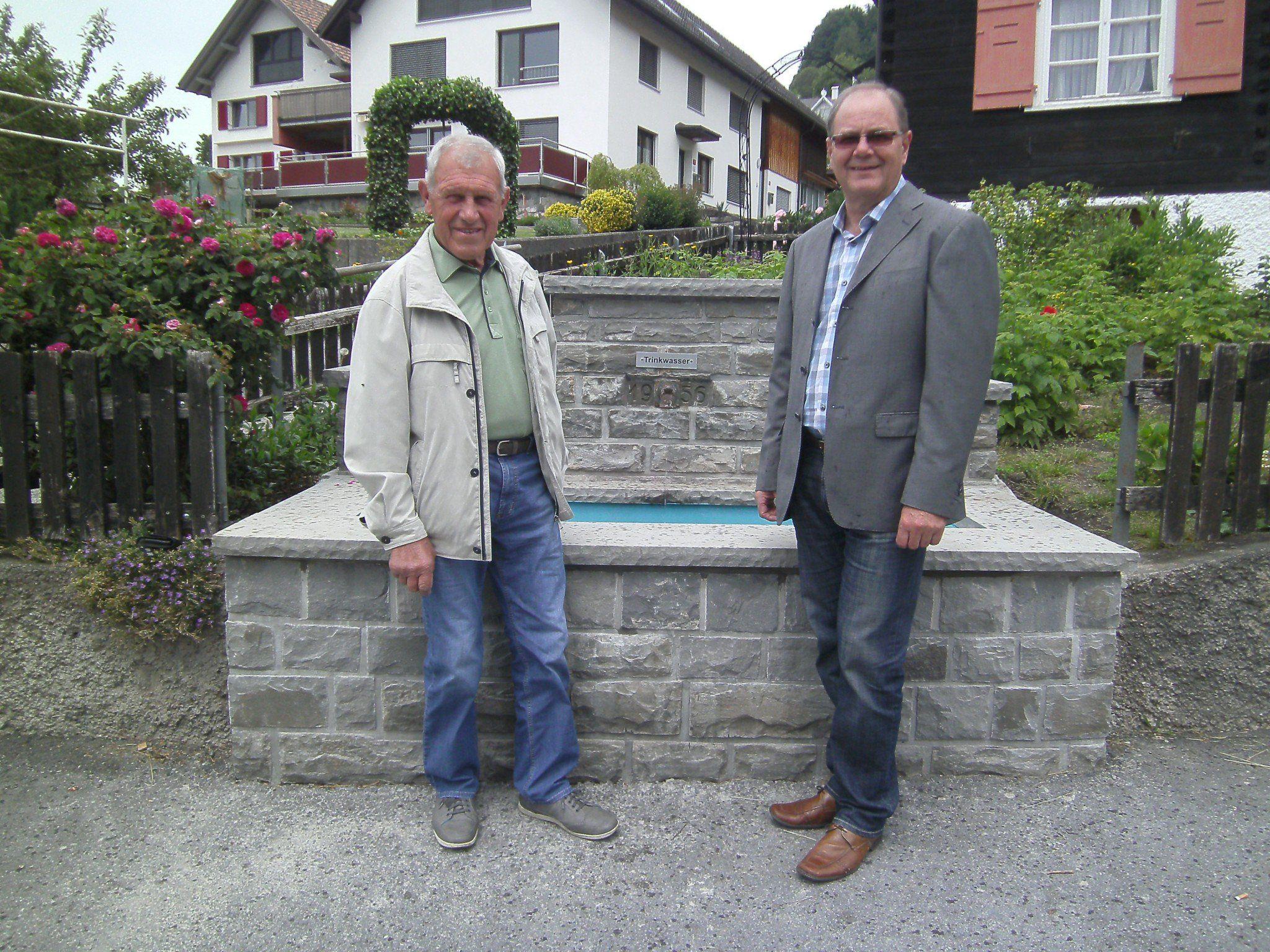Bgm. Reinhard Nachbaur (re.) und Steinmaurer Oswald Nägele vor dem neu sanierten Dorfbrunnen.
