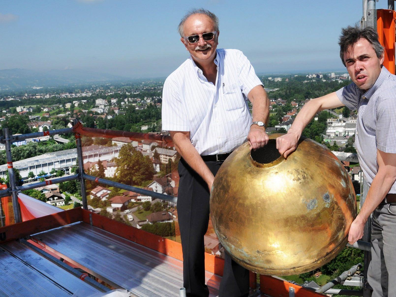 Pfarrer Johannes Sandor und Bürgermeister Hans Bertsch an der Kirchturmspitze mit dem vergoldeten Kirchturmknopf