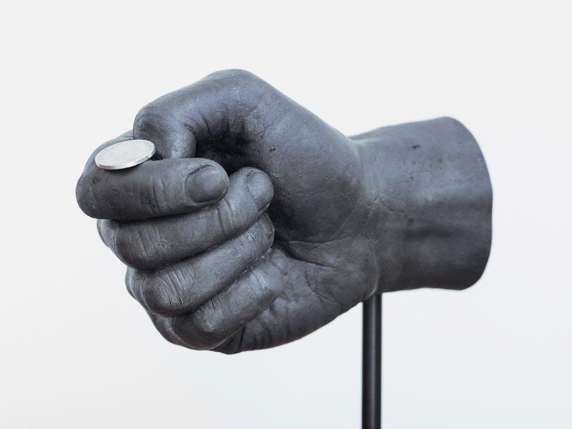 2012 entstand diese Bronzehand, die im Begriff ist eine Münze zu werfen.