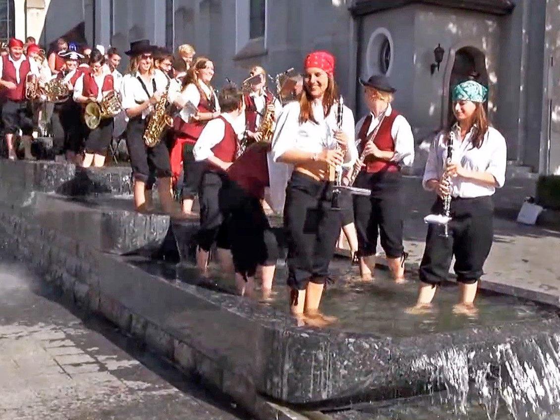 Mit ihrem Auftritt im Brunnen vor der Kirche wirbt die BM Höchst für das Musikfest am 13. September.