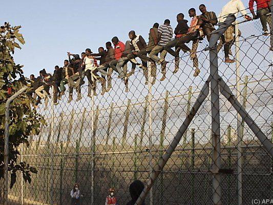 Flüchtlinge auf dem Grenzzaun von Melilla