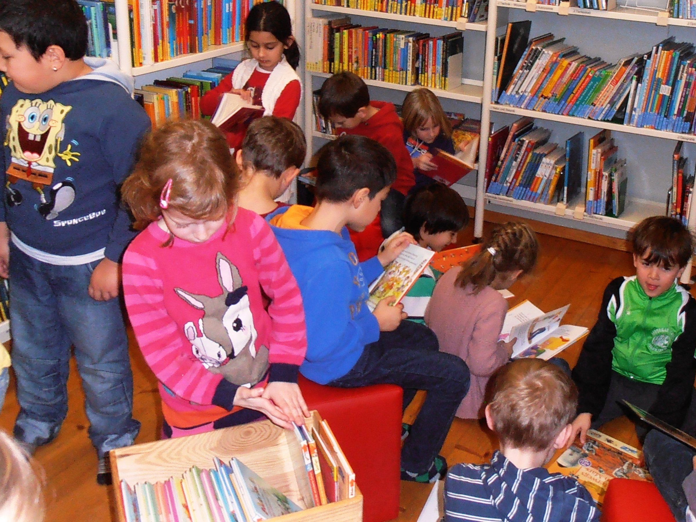 Kinder haben viel Spaß beim Schmökern in der Bibliothek Kinder haben viel Spaß beim Schmökern in der Bibliothek