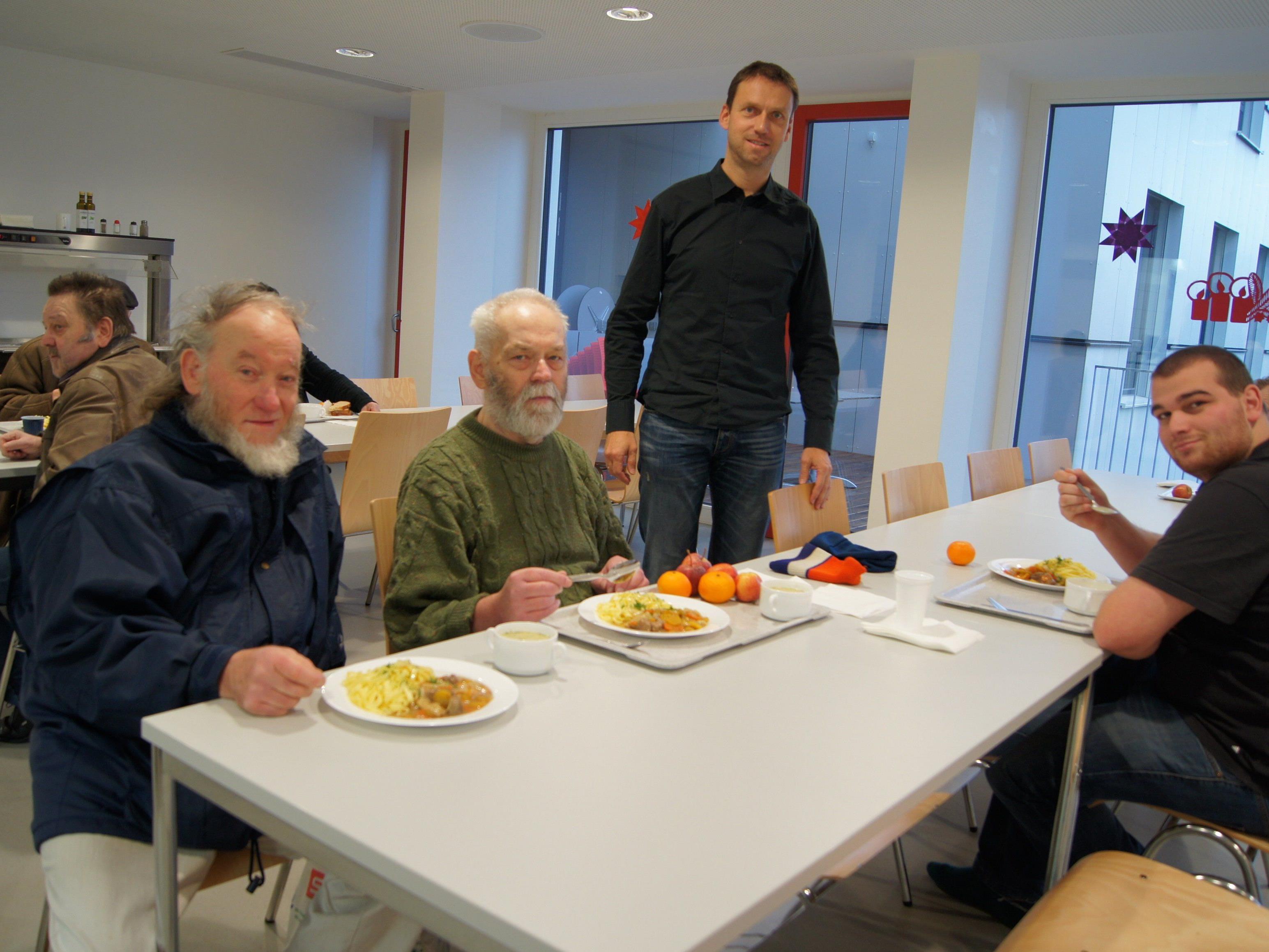 GF Peter Mayerhofer (Mitte) zeigt den Speisesaal im Kaplan-Bonetti-Haus, in dem an Heilig Abend gefeiert wird.