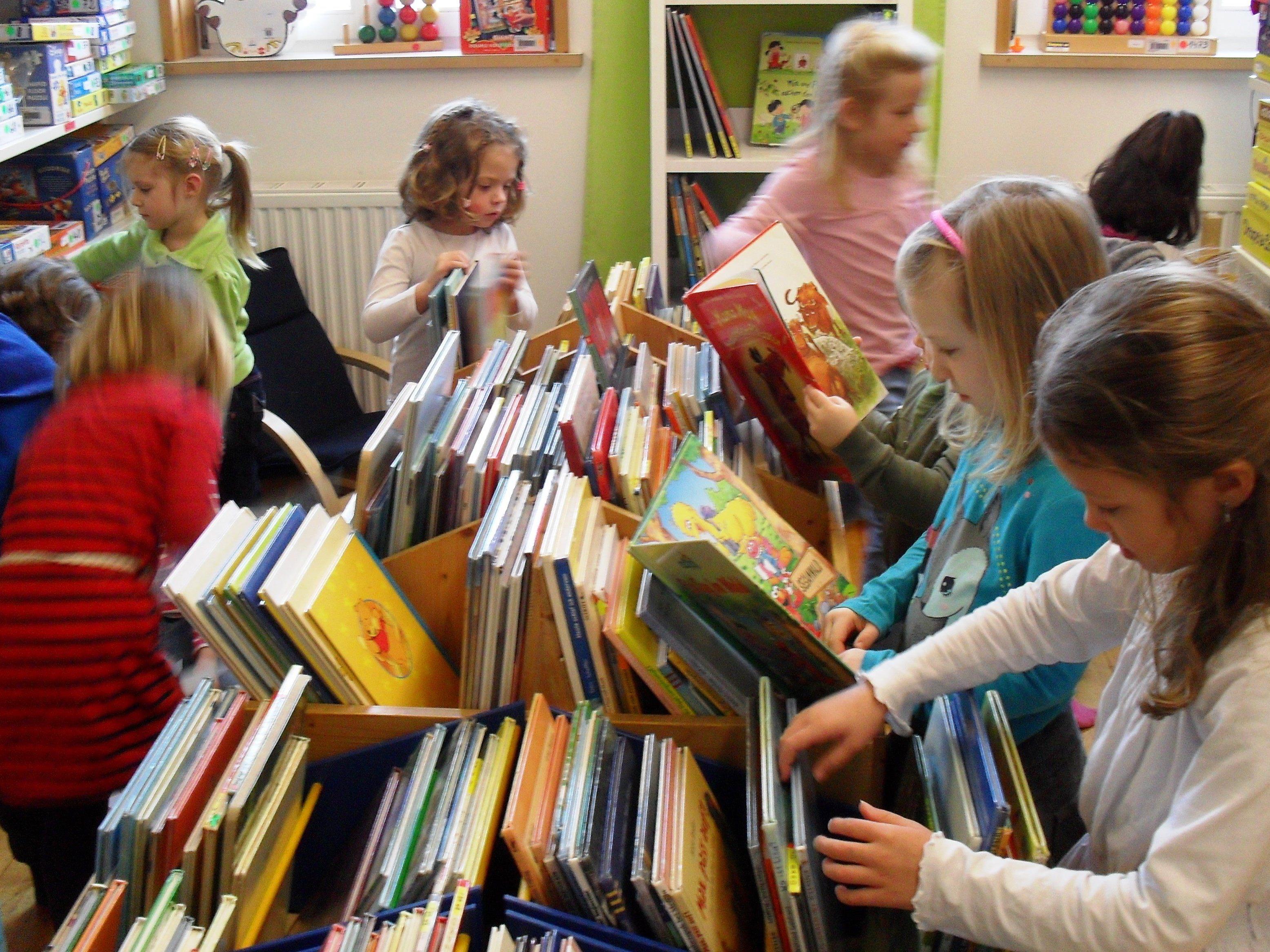 Kinder stöbern neugierig bei unseren Bilderbüchern Kinder stöbern neugierig bei unseren Bilderbüchern
