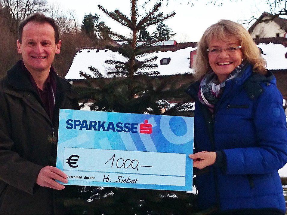 Sylvia Steinhauser vom Vorarlberger Kinderdorf freut sich über die verdoppelte Spende, die sie von Herrn Sieber entgegennimmt.