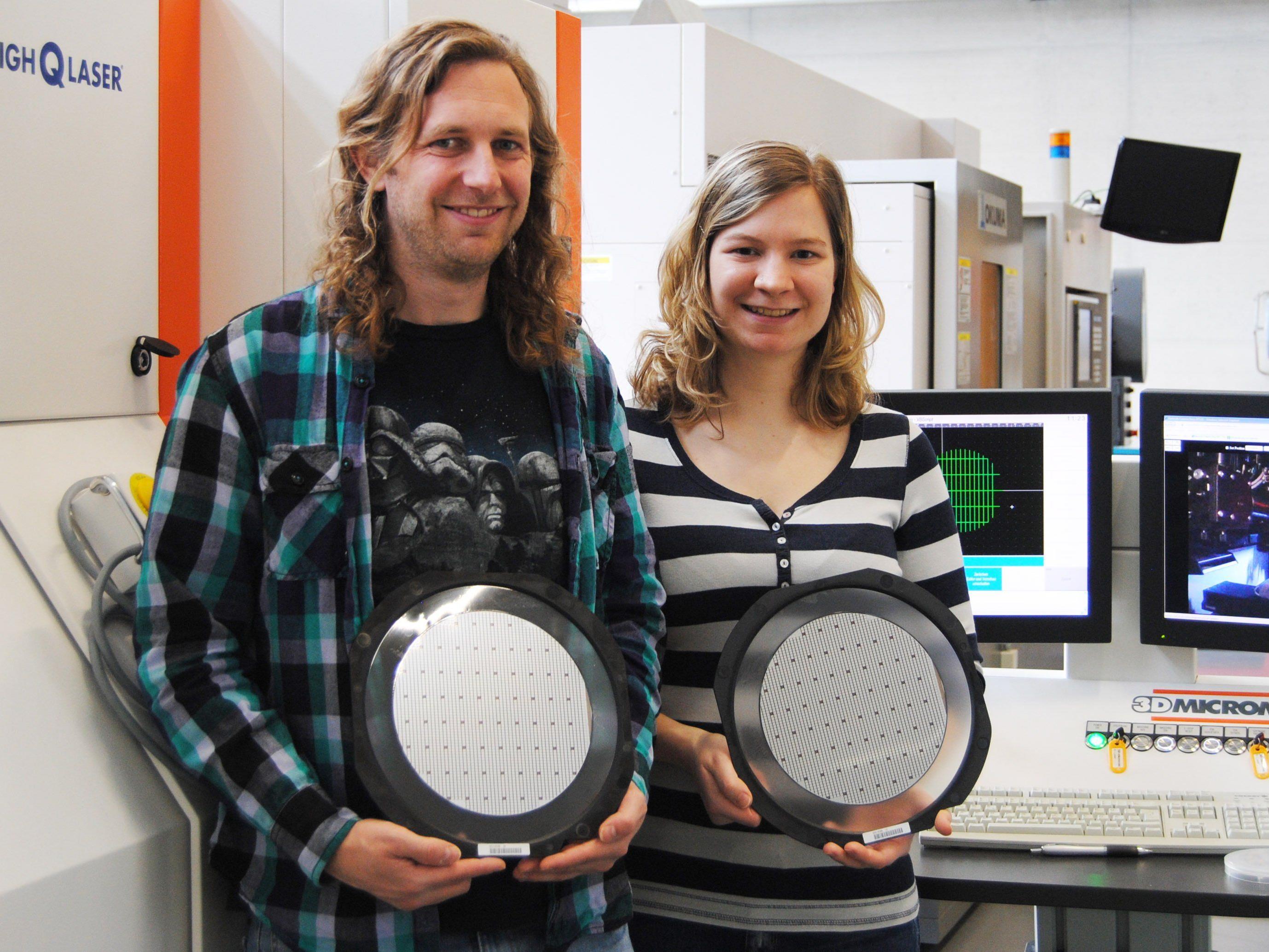 Matthias Domke und Bernadette Egle mit einem Si-Wafer, aus dem die Chips mittels Laser ausgeschnitten werden.