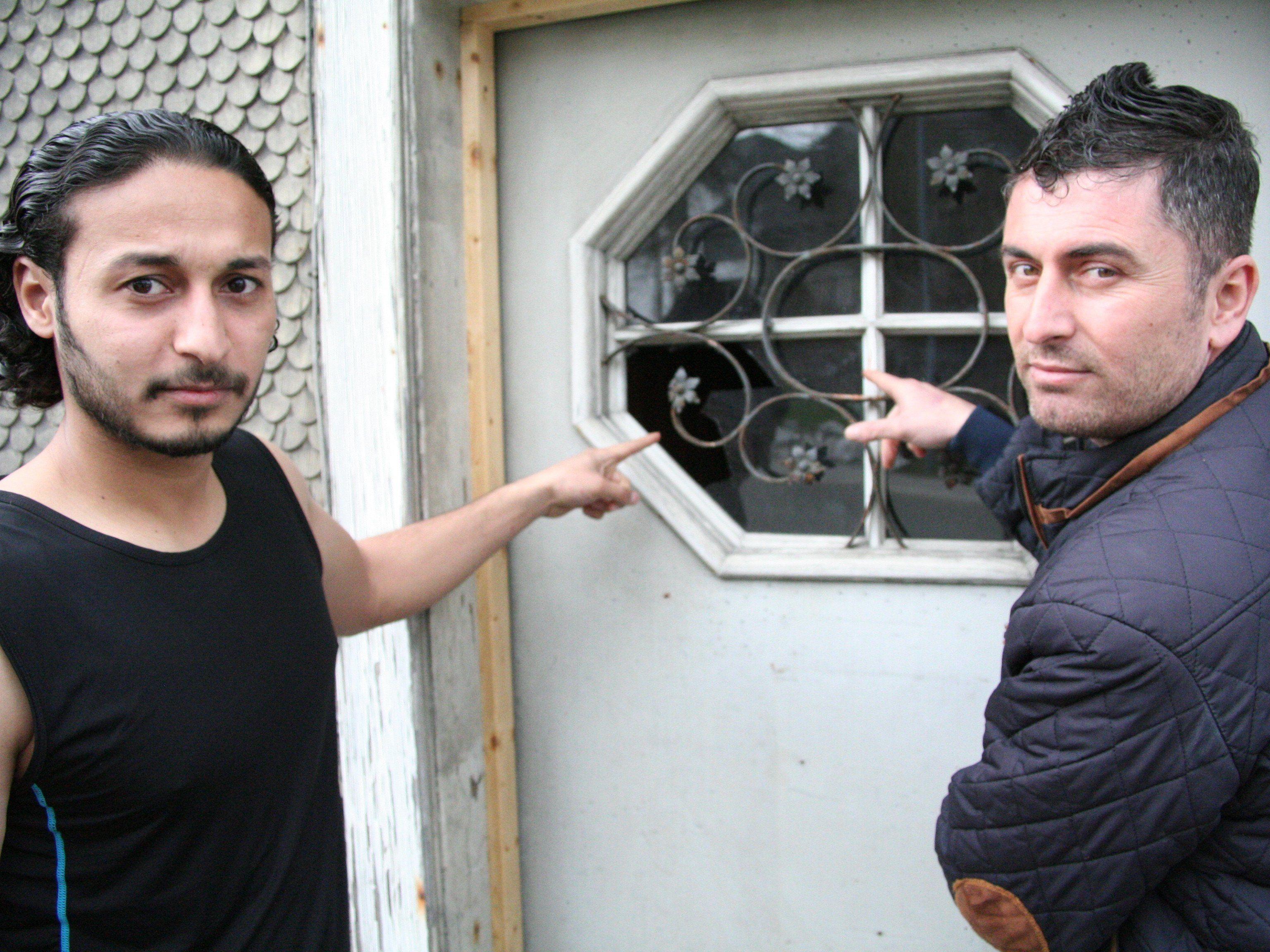 Schockiert: Leith (l.) und Azad zeigen auf das eingeschlagene Fenster der Eingangstür.