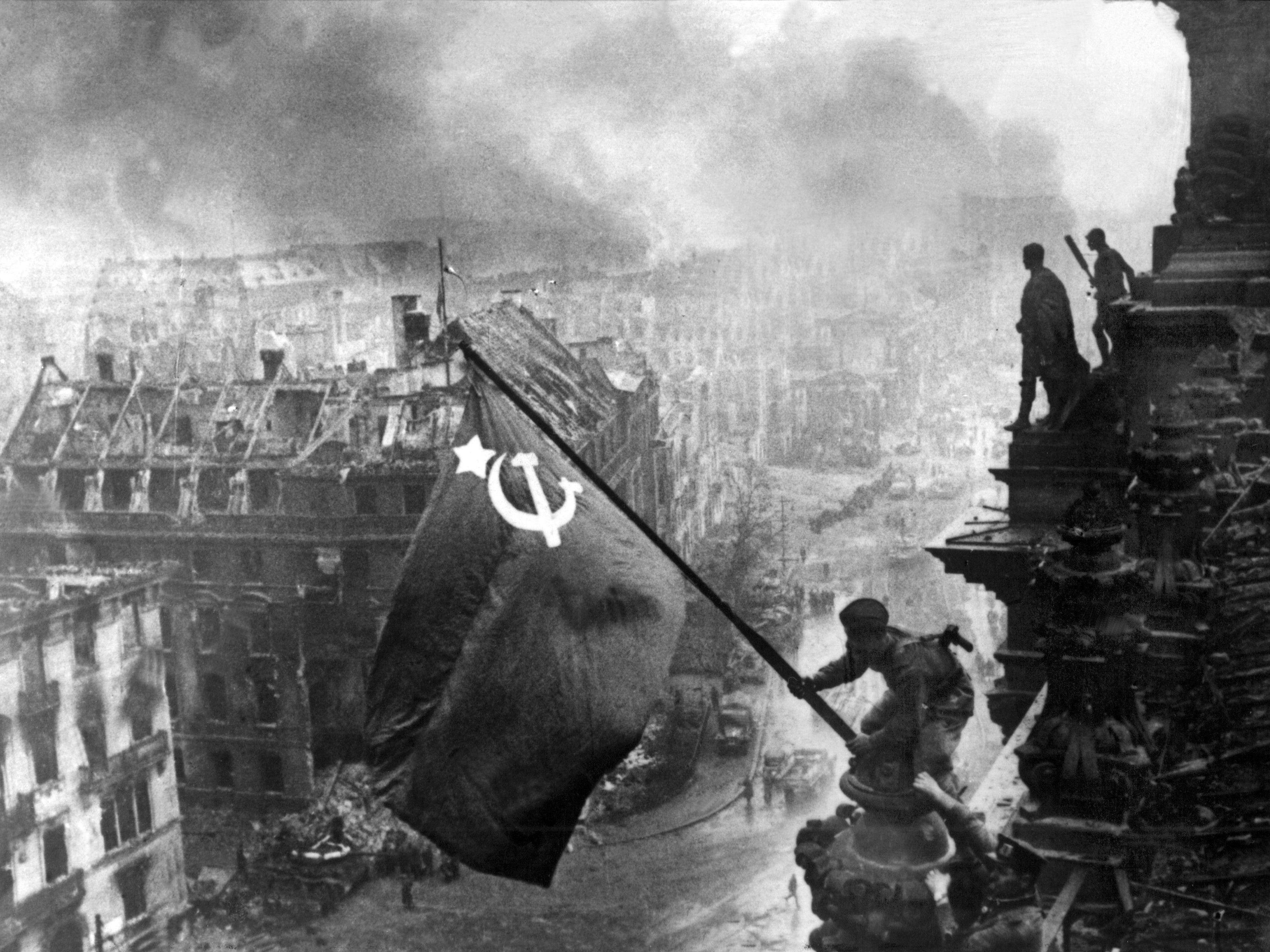 Der sowjetische Soldat Militon Kantarija hisst am 2. Mai 1945 die sowjetische Fahne auf dem Berliner Reichstag - eine nachgestellte Szene, Berlin war bereits am 30. April eingenommen worden.