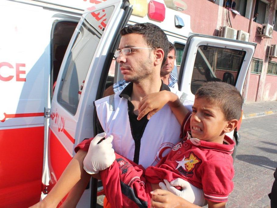 Gaza, Juli 2014: Mitarbeiter und Freiwillige des Palästinensischen Roten Halbmond leisten medizinische Versorgung und evakuieren die Verwundeten in Chan Yunis-Stadt, im südlichen Teil des Gazastreifens.