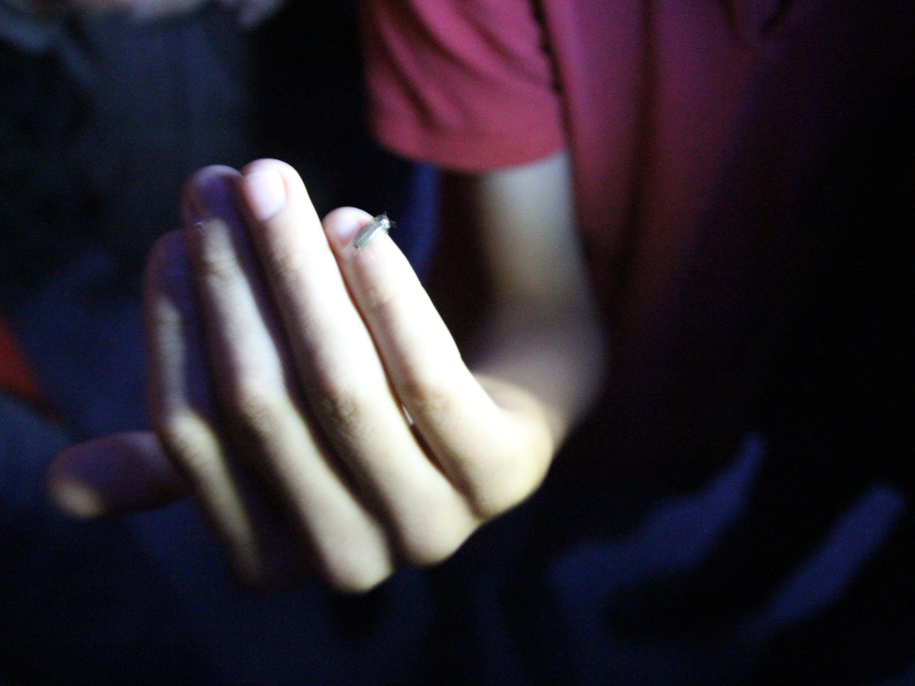 Ein Glühwürmchen auf dem Finger eines Kindes.