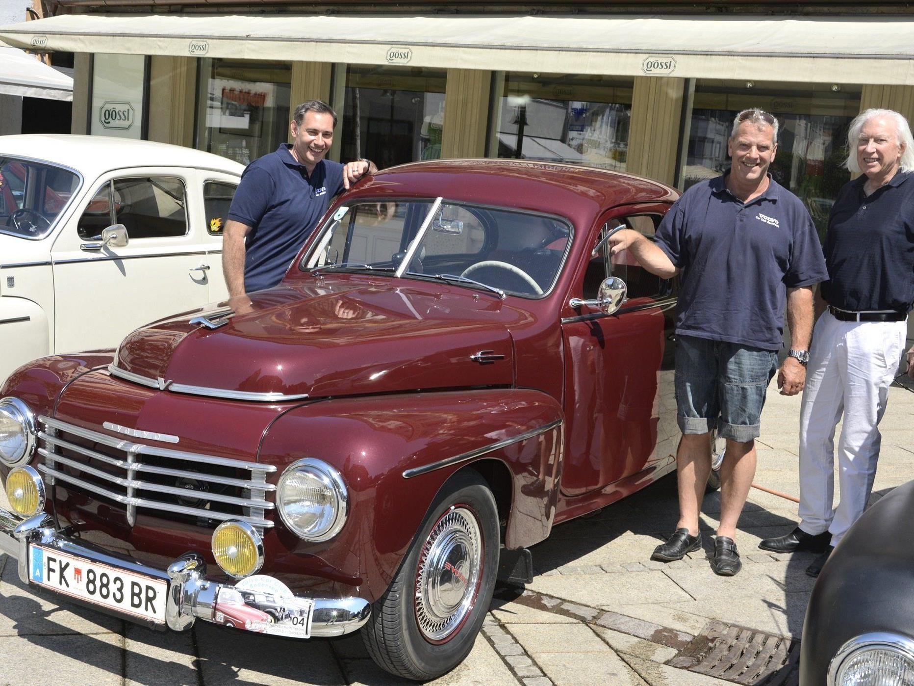 Thomas Niedermair und Jörg Knapp stellen sich neben Günter Drexel,  den stolzen Besitzer des ältesten Volvo-Modells aus dem Jahr 1953.