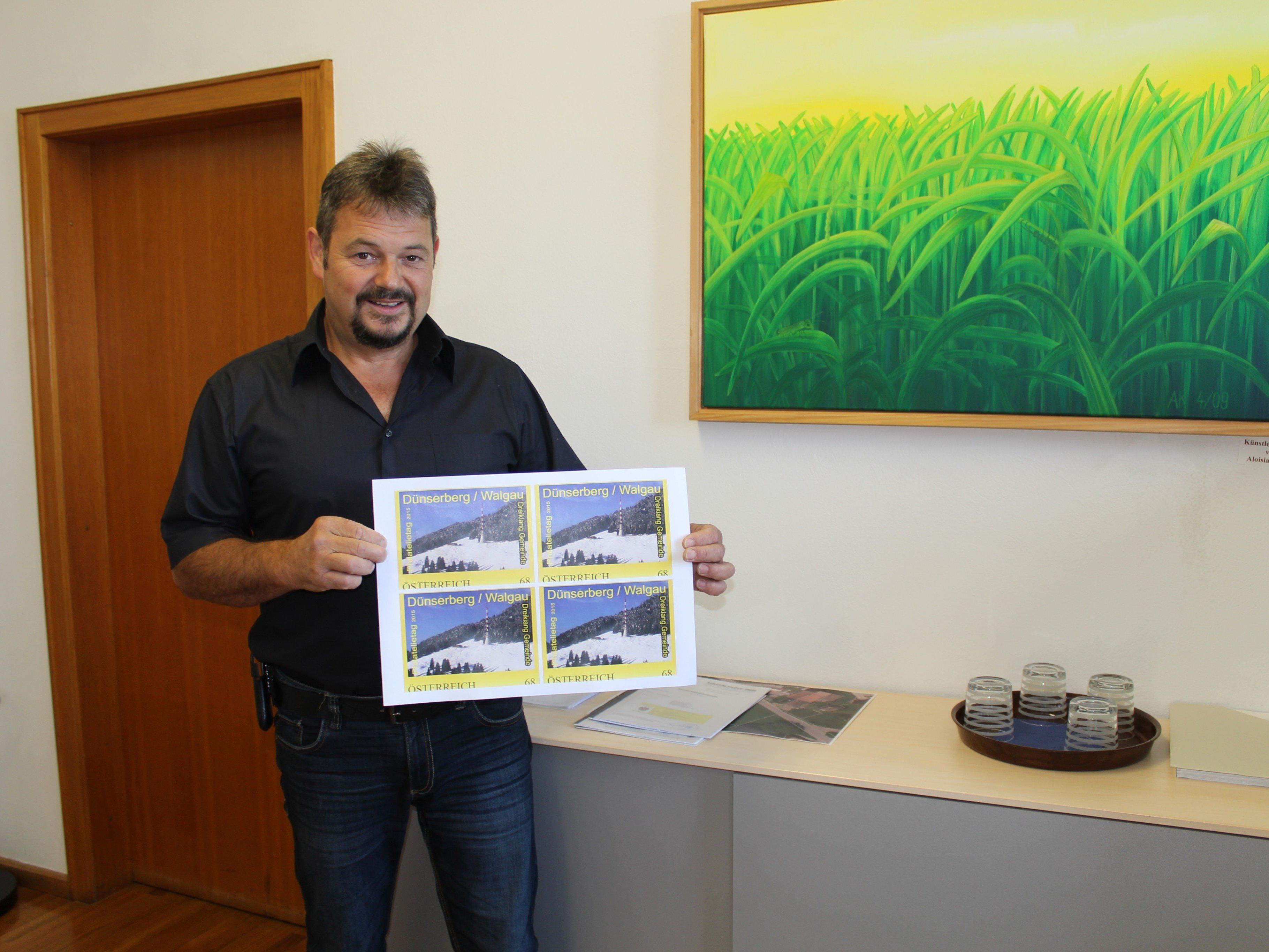 Walter Rauch präsentiert das Aussehen der Briefmarke mit dem "Dünser Älpele"