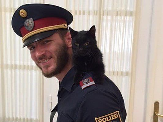 Einer der Polizisten mit der entwischten und geretteten Katze