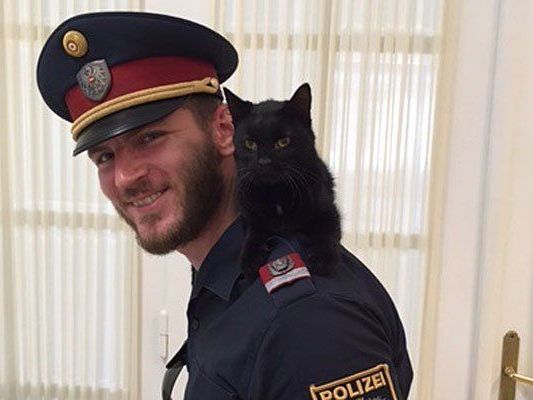 Einer der Polizisten mit der entwischten und geretteten Katze Einer der Polizisten mit der entwischten und geretteten Katze