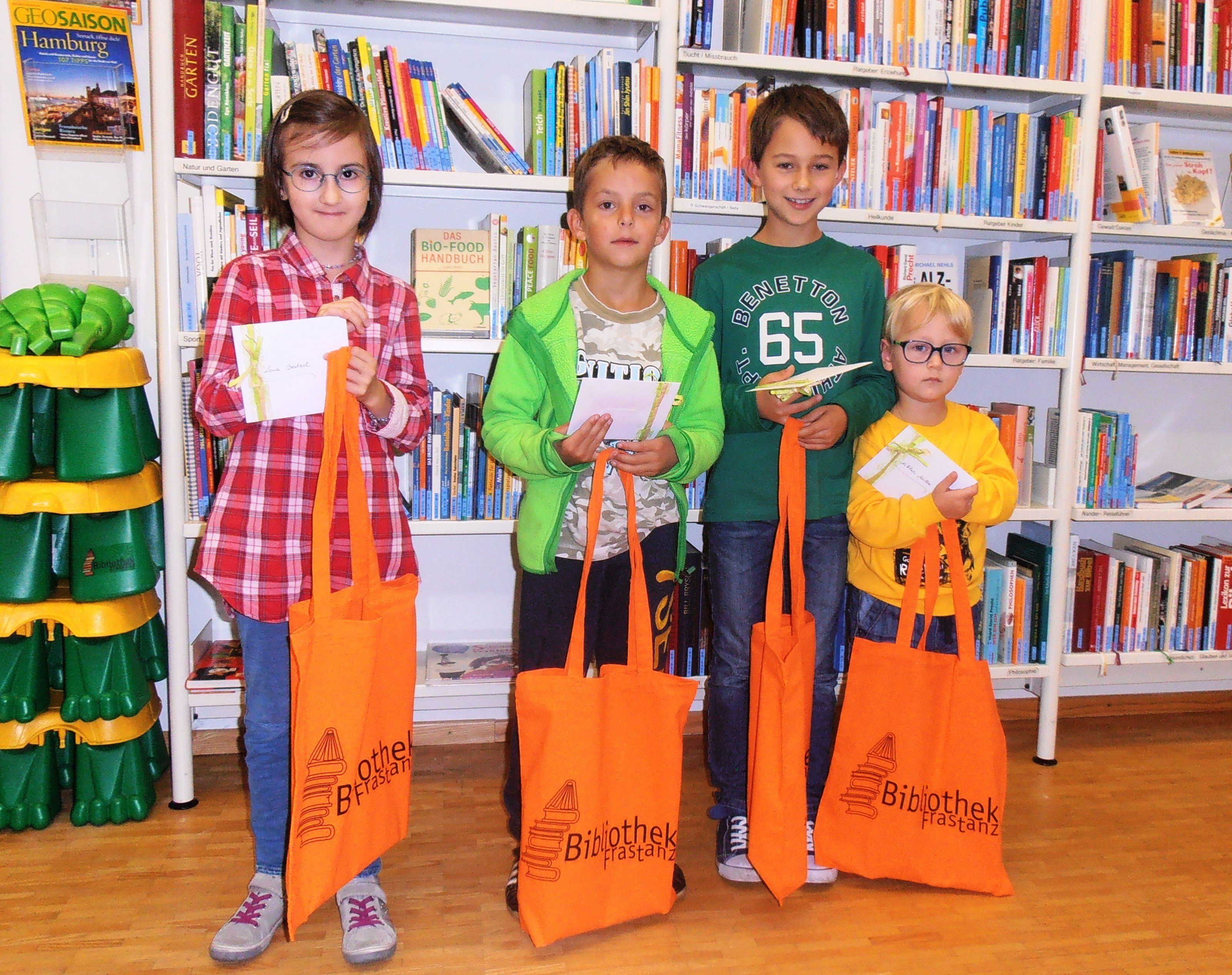 Die Kinder freuen sich über Buchgutscheine und eine neue Bibliothekstasche mit Die Kinder freuen sich über Buchgutscheine und eine neue Bibliothekstasche mit