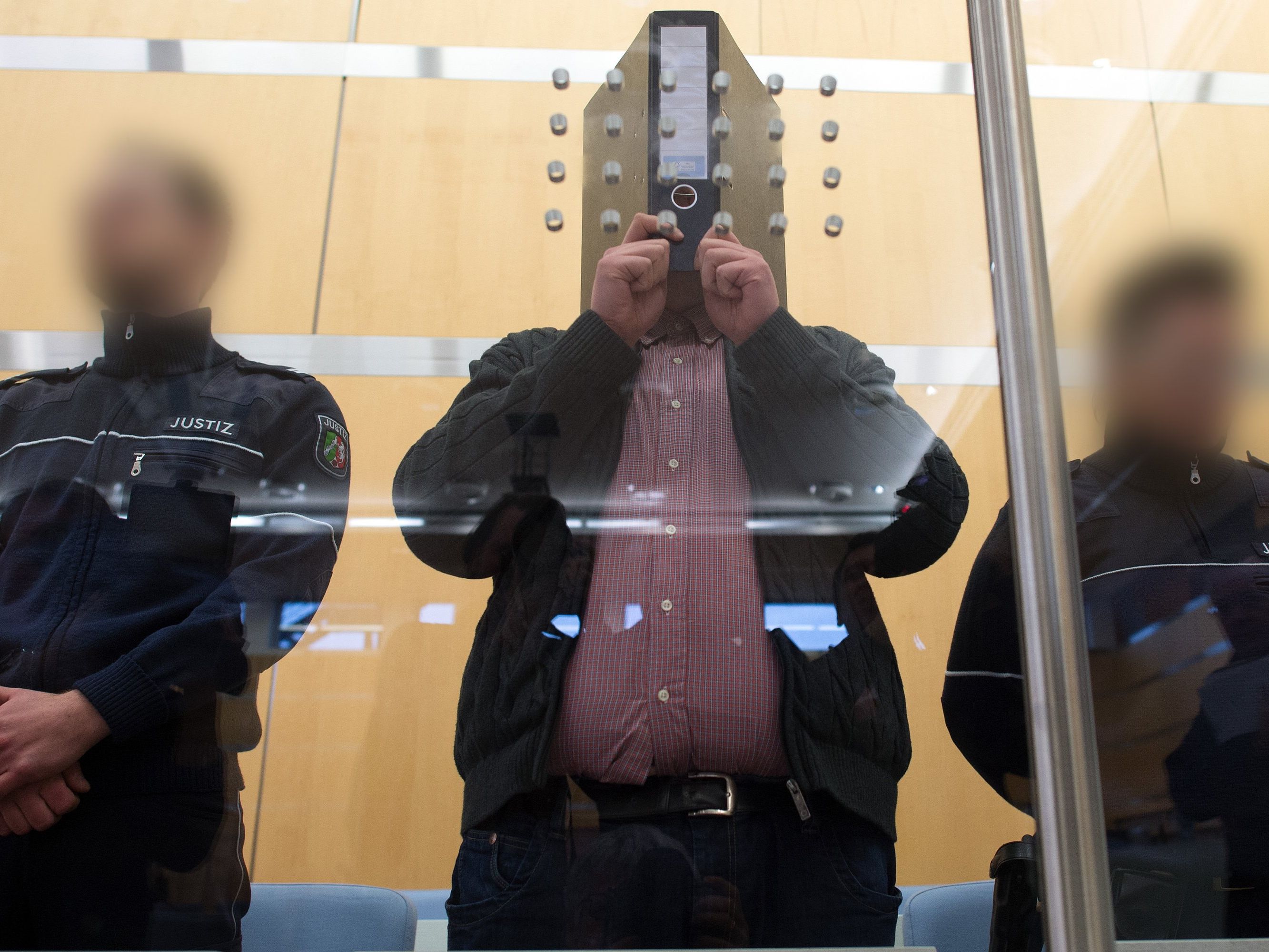 Syrien-Rückkehrer Nils D. mit einem Aktenorder vor dem Gesicht im Gerichtssaal in Düsseldorf. Syrien-Rückkehrer Nils D. mit einem Aktenorder vor dem Gesicht im Gerichtssaal in Düsseldorf.