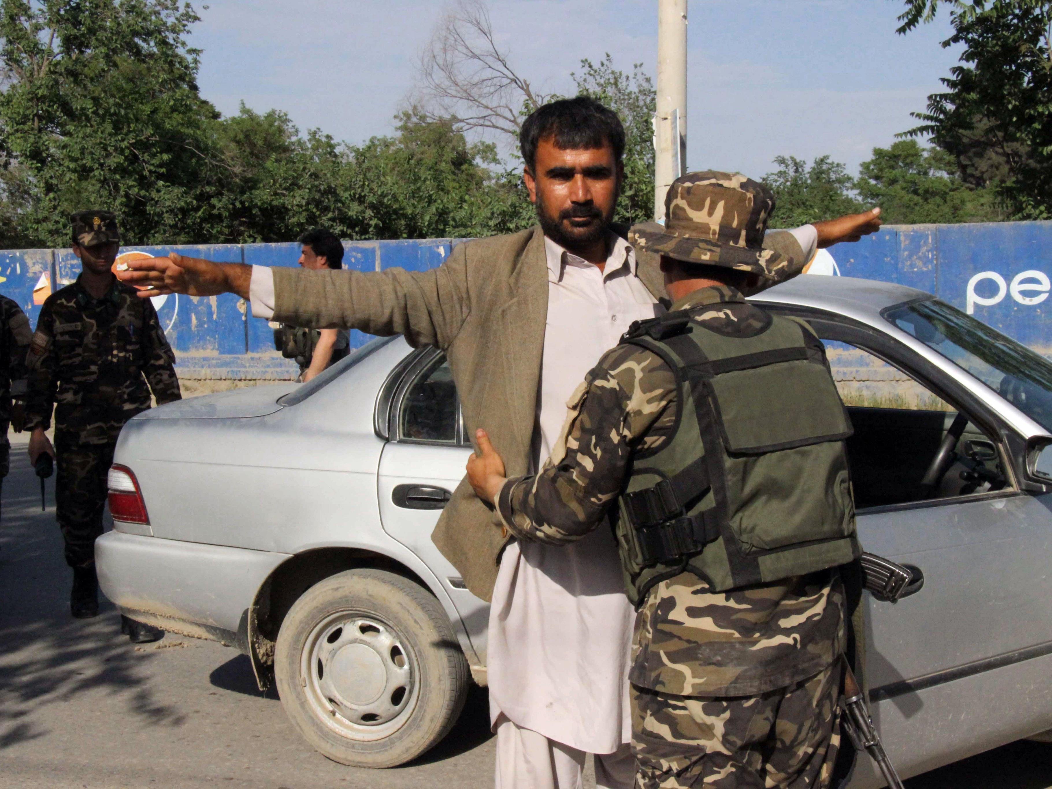 Afghanische Sicherheitskräfte kontrollieren Pendler an einem Checkpoint in Kunduz