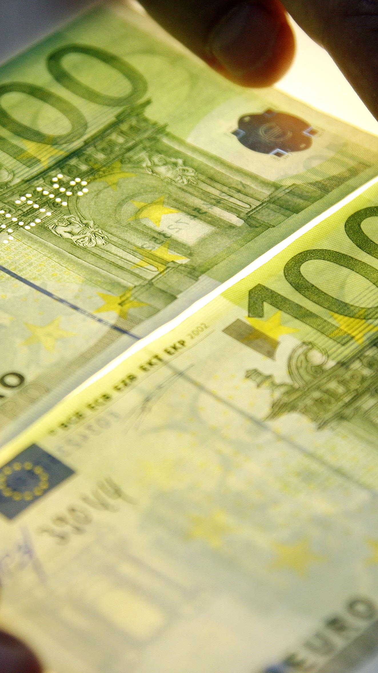 Das Bild zeigt einen echten, rechts unten, und einen gefälschten, links oben, 100 Euro-Schein.