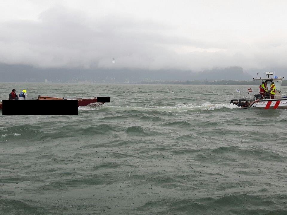 Das schwer beschädigte Schiff wird von den Einsatzkräften zurück in den Hafen geschleppt