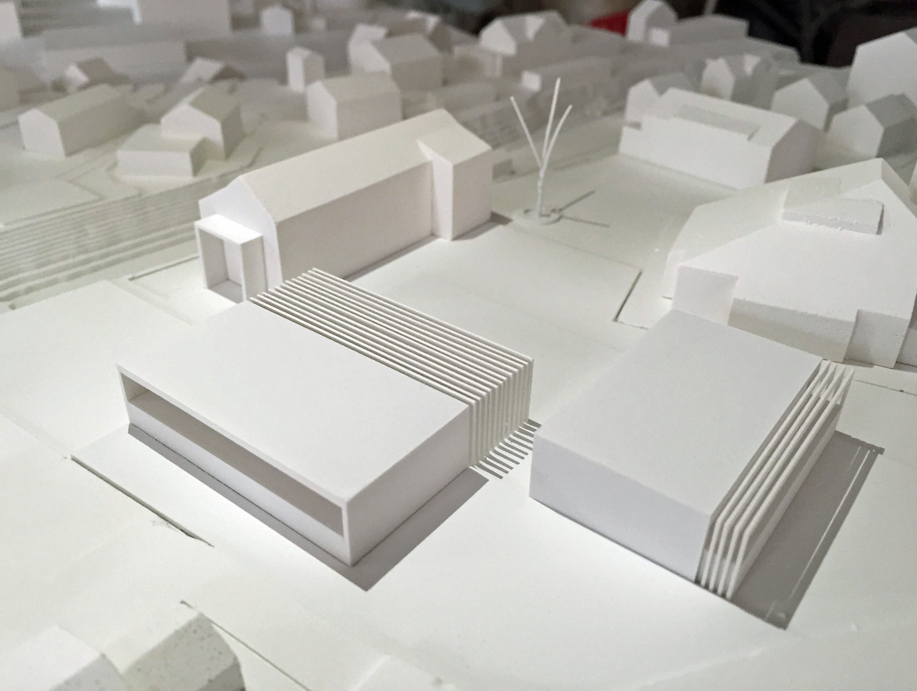 Das Projekt besteht aus zwei kubischen Baukörpern, die sich mit der bestehenden Bebauung ergänzen und einen neuen Dorfplatz ergeben. Das Projekt besteht aus zwei kubischen Baukörpern, die sich mit der bestehenden Bebauung ergänzen und einen neuen Dorfplatz ergeben.