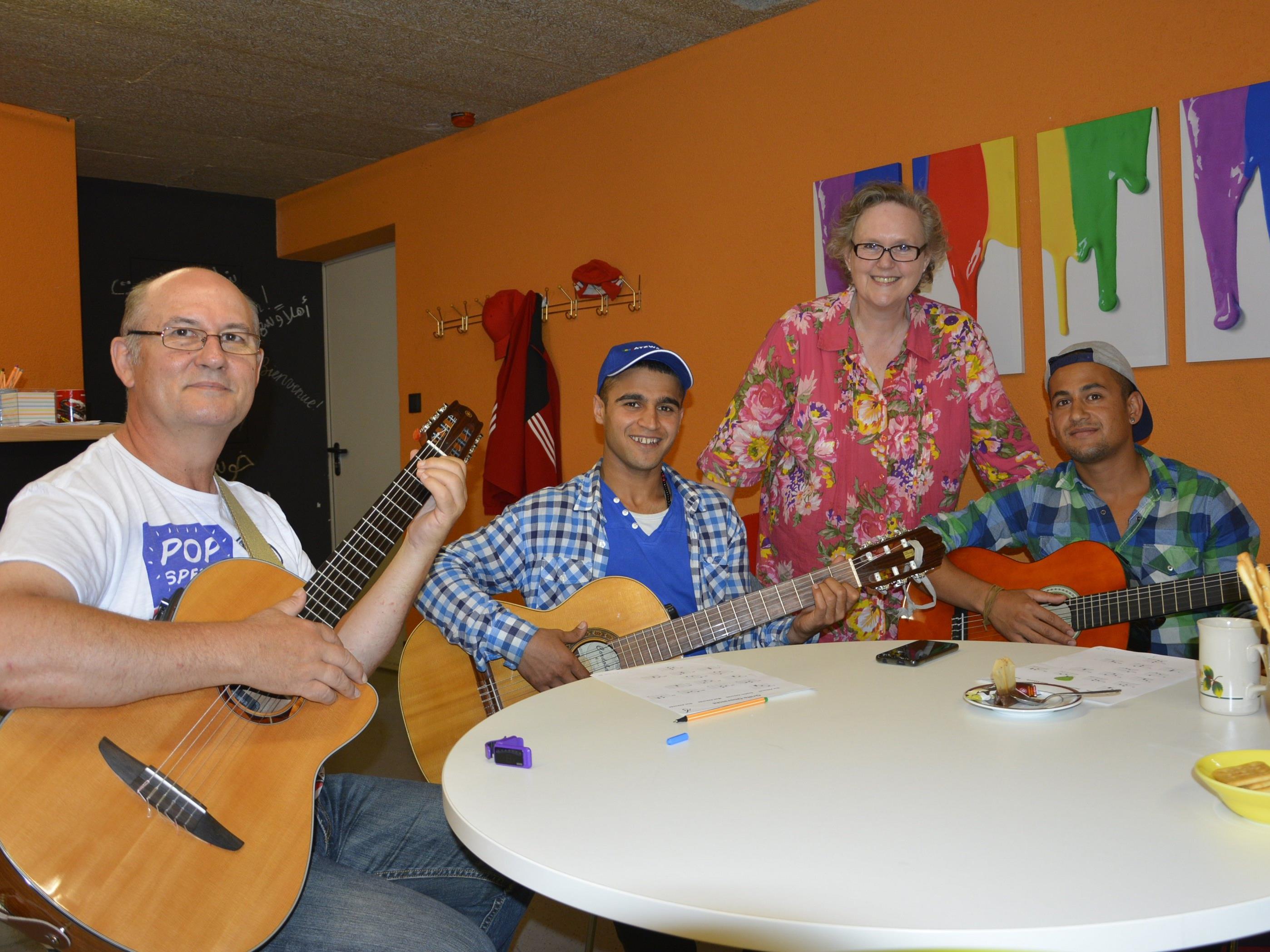Zwei junge Flüchtlinge aus Afghanistan lernen bei Heribert Thaler Gitarre spielen. Die Koordination der Treffen übernimmt Emma Rosenzopf.