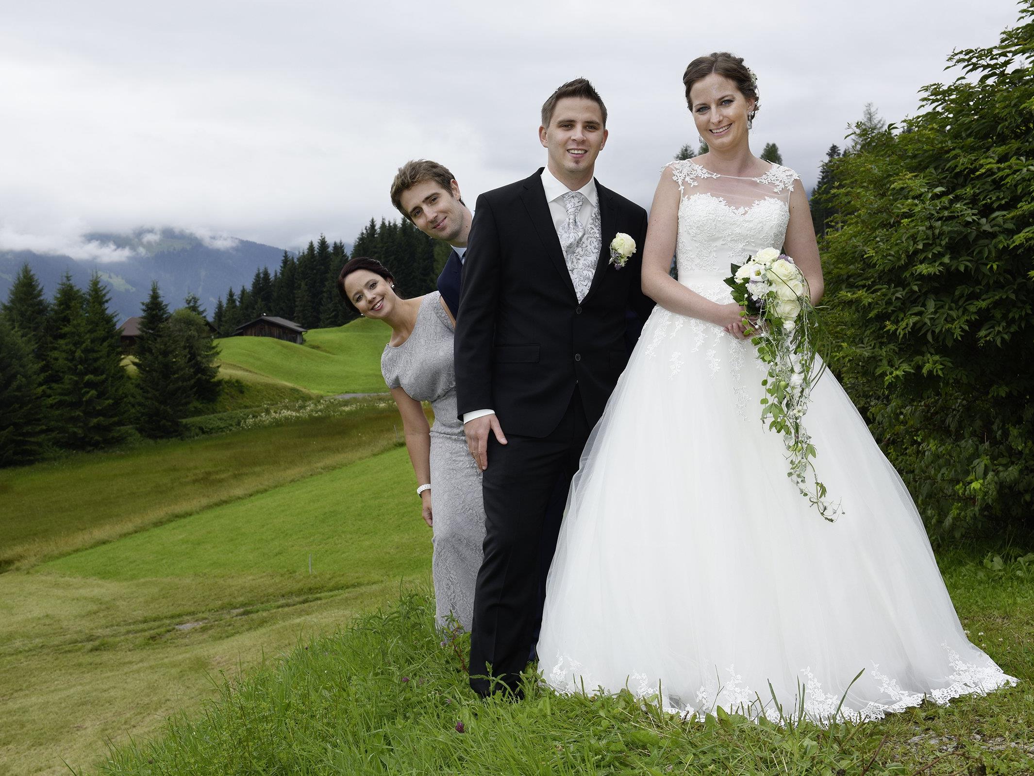 Das  Brautpaar mit seinen Trauzeugen posiert in luftiger Höhe für den Fotografen.