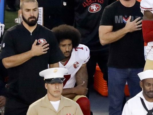 Colin Kaepernick (mitte) kniet während der US-Hymne vor dem Pre-Season-Spiel der San Francisco 49ers gegen die San Diego Chargers. Colin Kaepernick (mitte) kniet während der US-Hymne vor dem Pre-Season-Spiel der San Francisco 49ers gegen die San Diego Chargers.